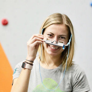 Girl wearing EyeSend Belay Glasses inside of the climbing gym.